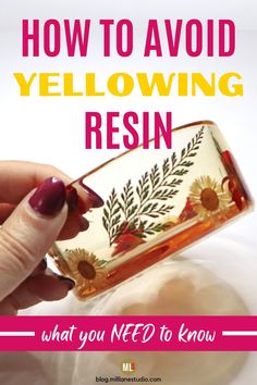 a woman's hand holding a glass container with flowers on it and the words how to avoid yellowing resin