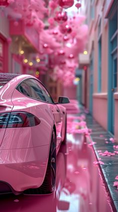 a pink car parked in front of a building with flowers hanging from it's ceiling