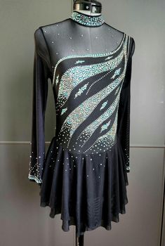 a black and silver dress with sequins on the back, sitting on a mannequin