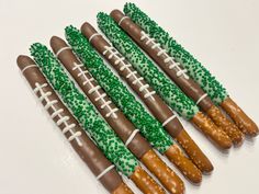 six football shaped pretzels with green sprinkles and white frosting