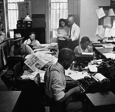 black and white photograph of people working in an office