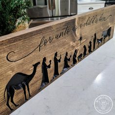 a wooden sign with silhouettes of people and animals on it