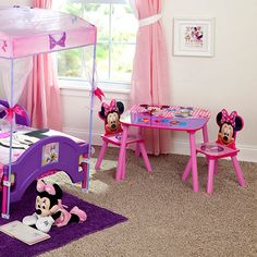 a child's bedroom decorated in pink and purple with minnie mouse decorations on the bed