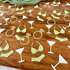 paper cutouts are arranged on a wooden table with green napkins and wine glasses