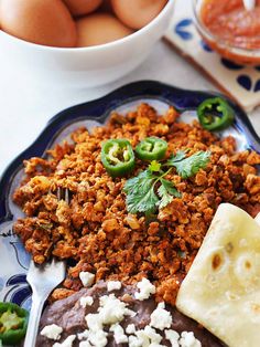 an assortment of food on a plate with eggs in the background