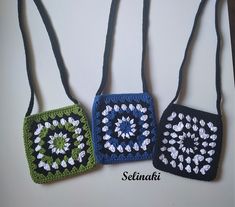 three crocheted purses are hanging on a white surface with the words selimak written below them