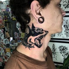 a woman with a tattoo on her neck and behind her ear is an image of a fish