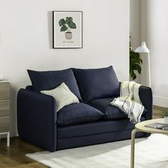 a living room with a blue couch and white rug