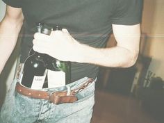 a man is holding two bottles in his pocket