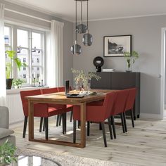 a dining room table with red chairs around it