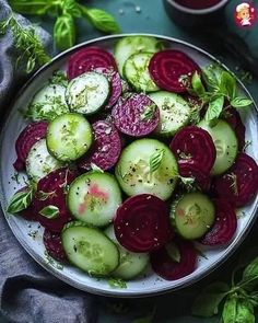 a white plate topped with sliced up beets and cucumbers