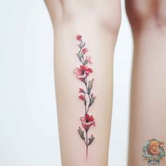 a woman's arm with red flowers on it and the bottom part of her leg