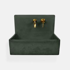 a green sink with two gold faucets on it