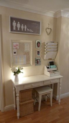 a white desk with some pictures on the wall