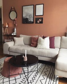 a living room with a white couch and coffee table in front of a brown wall