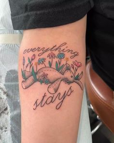 a woman with a tattoo on her arm that says everything stays