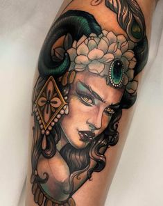 a woman's leg with tattoos on it and a snake in her hair,