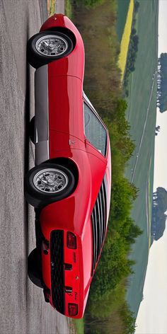 a red sports car is parked on the side of the road