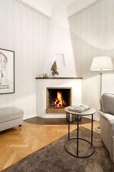 a living room with a fire place next to a couch and table in front of it