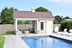 a backyard with a pool, lounge chairs and an outdoor living area in the background