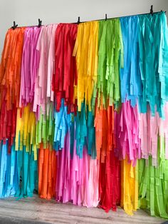 colorful streamers hanging on the side of a wall in front of a white wall