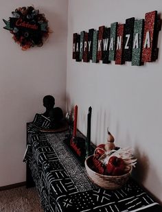 a black and white table topped with apples next to a wall mounted art piece on the wall