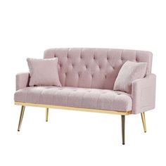 a pink couch sitting on top of a white floor next to a wooden frame and pillow