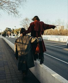 a man and woman walking down the side of a road