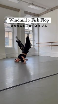 a person is doing a handstand on the floor in an empty dance studio