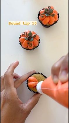 someone is decorating cupcakes with orange frosting