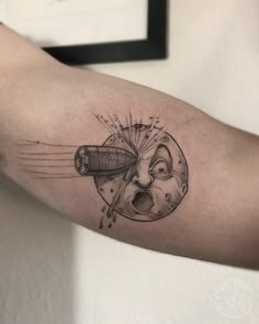 a man's arm with a tattoo on it that has an image of a rocket ship coming out of the hole