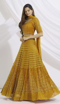 Mustard yellow lehenga with floral embroidered motifs, paired with embroidered blouse and dupatta, featuring a square neckline, elbow-length sleeves, cutwork dupatta, side tassel tie-up lehenga, back tassel tie-up blouse, and tassel border. Neeta Lulla, Georgette Fabric, Designer Gowns, Bridal Lehenga