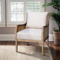 a white chair sitting in front of a window with shutters on it's windowsill