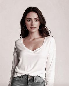 a woman in white shirt and jeans posing for the camera