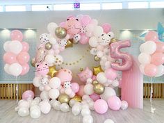 the balloon arch is decorated with pink, white and gold balloons that spell out 5