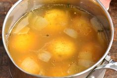 a pot filled with soup sitting on top of a wooden table