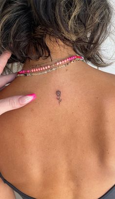 the back of a woman's neck with a small tattoo on it