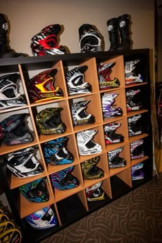 a room filled with lots of different types of helmets on shelves next to each other