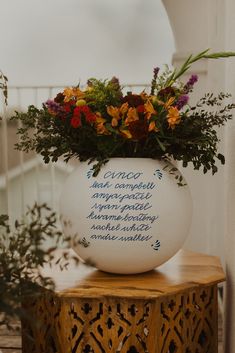 a vase filled with flowers sitting on top of a wooden table