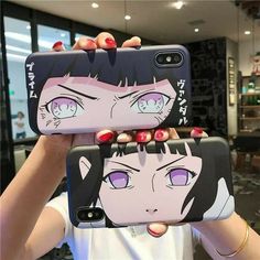 a woman holding up two cell phones with anime characters on them in front of her face