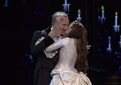 a man and woman are kissing on stage