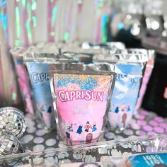 there are many cups on the table with confetti and candy in them for sale