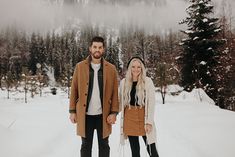 a man and woman are standing in the snow