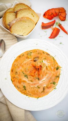 there is a bowl of soup and bread on the table