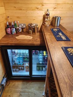 two refrigerators are next to each other in a small room with wood paneling