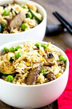 two white bowls filled with rice and vegetables