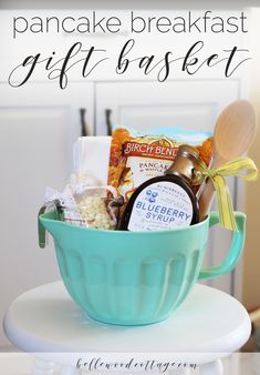 a teal bowl filled with food on top of a white table next to the words pancake breakfast gift basket