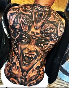 a man with tattoos on his back and head covered in demonic creatures, all around him