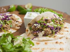 two tacos on a plate with cilantro and onions