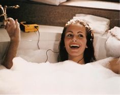 a woman in a bathtub with headphones on